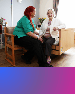 A Hafod carer and resident sat on a bed