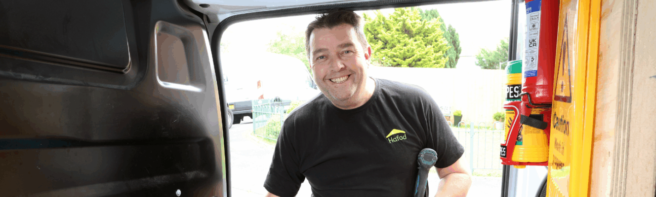 A man wearing a Hafod tshirt getting some tools out of a van
