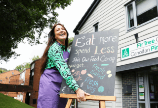 Hafod Housing Association Neighbourhood coach holding a board for a food pantry infront of Fir Tree Drive Centre