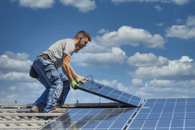 men fitting solar panels on a roof